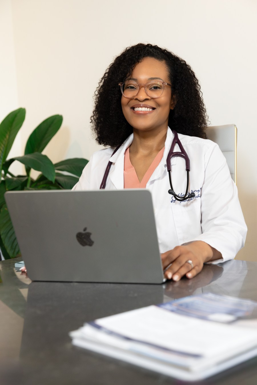 Dr. Sharifa Avery smiling at her desk with a laptop