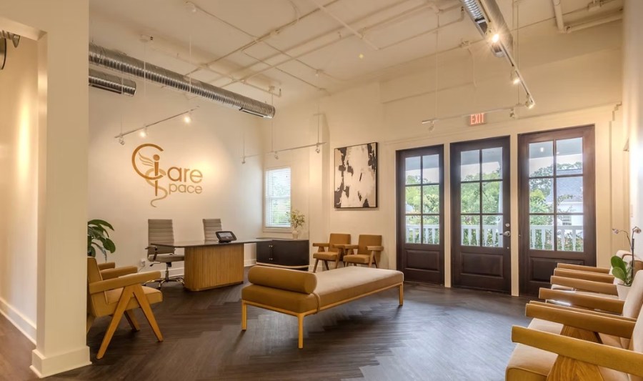 Bright clinic lobby with front desk, seating, and French doors